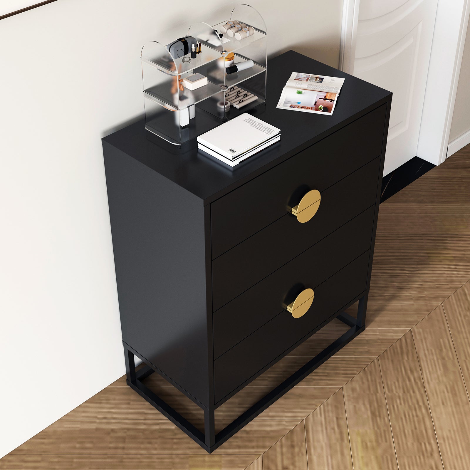 Abigail 76cm Tallboy Dresser with Storage - Black, featuring a matte-black three-drawer design with round brass pulls, topped with an acrylic cosmetics organizer, books, and an open magazine.