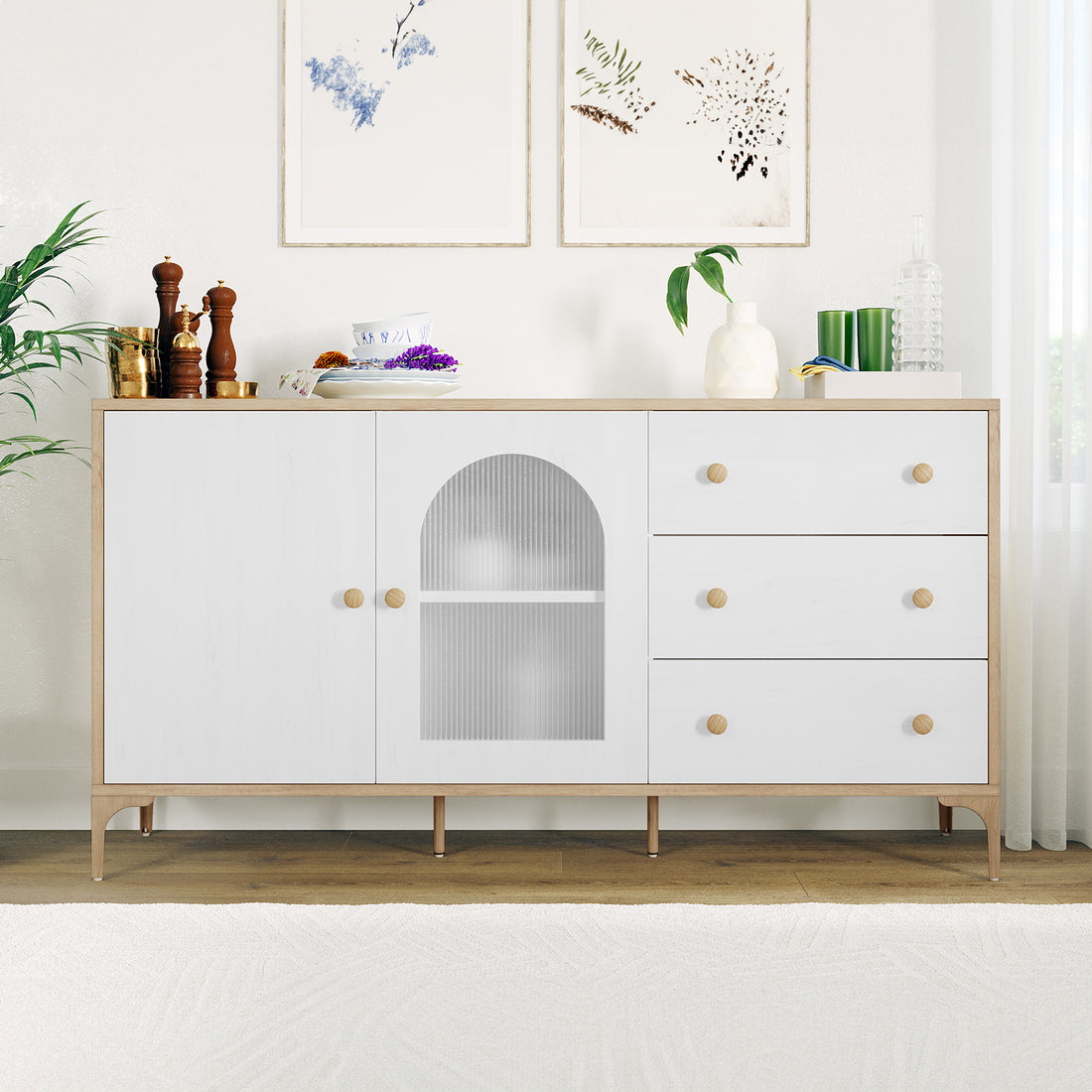 Afra 80cm Buffet Cabinet with Glass Doors in White & Natural, featuring a light wood frame, white fronts, brass vessels, bowls, vase, candles, and prints, creating a modern and elegant vignette.