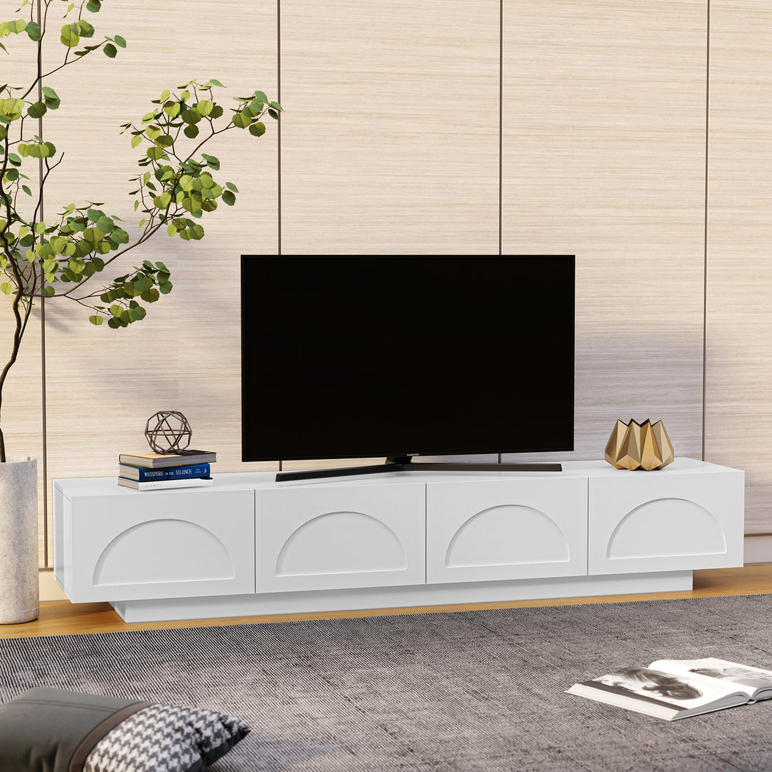 Archen 200cm 4 Drawer Storage TV Entertainment Unit in White features a sleek design with embossed half-circle motifs, topped by a flat-screen TV, books, and decor, against a wood-textured wall.