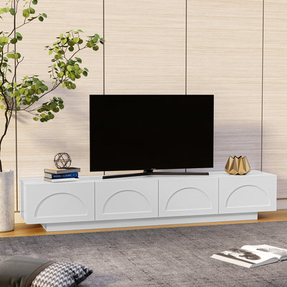 Archen 200cm 4 Drawer Storage TV Entertainment Unit in White features a sleek design with embossed half-circle motifs, topped by a flat-screen TV, books, and decor, against a wood-textured wall.