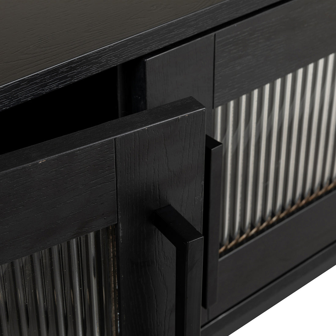 Ashley 160cm TV Unit with Fluted Glass Door Black, featuring a modern design with matte-black stained wood, vertically fluted glass panel, and a rectangular pull-handle on a slightly ajar door.