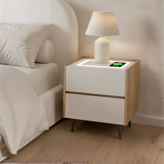 Beth Smart Wireless Bedside Table in White & Natural features a two-drawer design with a sleek table lamp and integrated wireless charger, complementing a minimalist bedroom corner with a modern aesthetic.