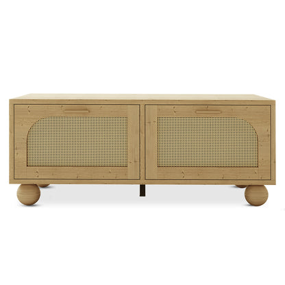 Carlo 110cm Rattan Coffee Table with Storage in Natural featuring a rectangular top, two rattan-paneled cabinet doors with horizontal handles, and spherical wooden feet for a minimalist, elevated look.