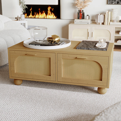 Carlo 110cm Rattan Coffee Table with Storage in Natural, featuring woven-rattan front panels and bun feet, adorned with decorative trays, a lit votive candle, and situated in a cozy, modern-organic living room setting.