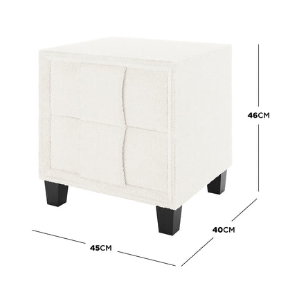 Crossandra 2 Drawer Fabric Bedside Table in Cream White, featuring cream-colored bouclé upholstery with a tufted grid pattern, supported by four short, tapered black wooden legs. Measures approximately 45 cm wide, 40 cm deep, and 46 cm tall.