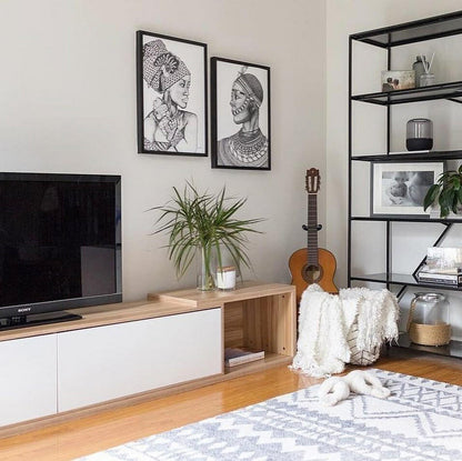 Eloise Entertainment Unit with Shelves - White displayed with a plant in a glass vase and a stuffed animal, highlighting its modern design and open shelving for stylish living room organization.