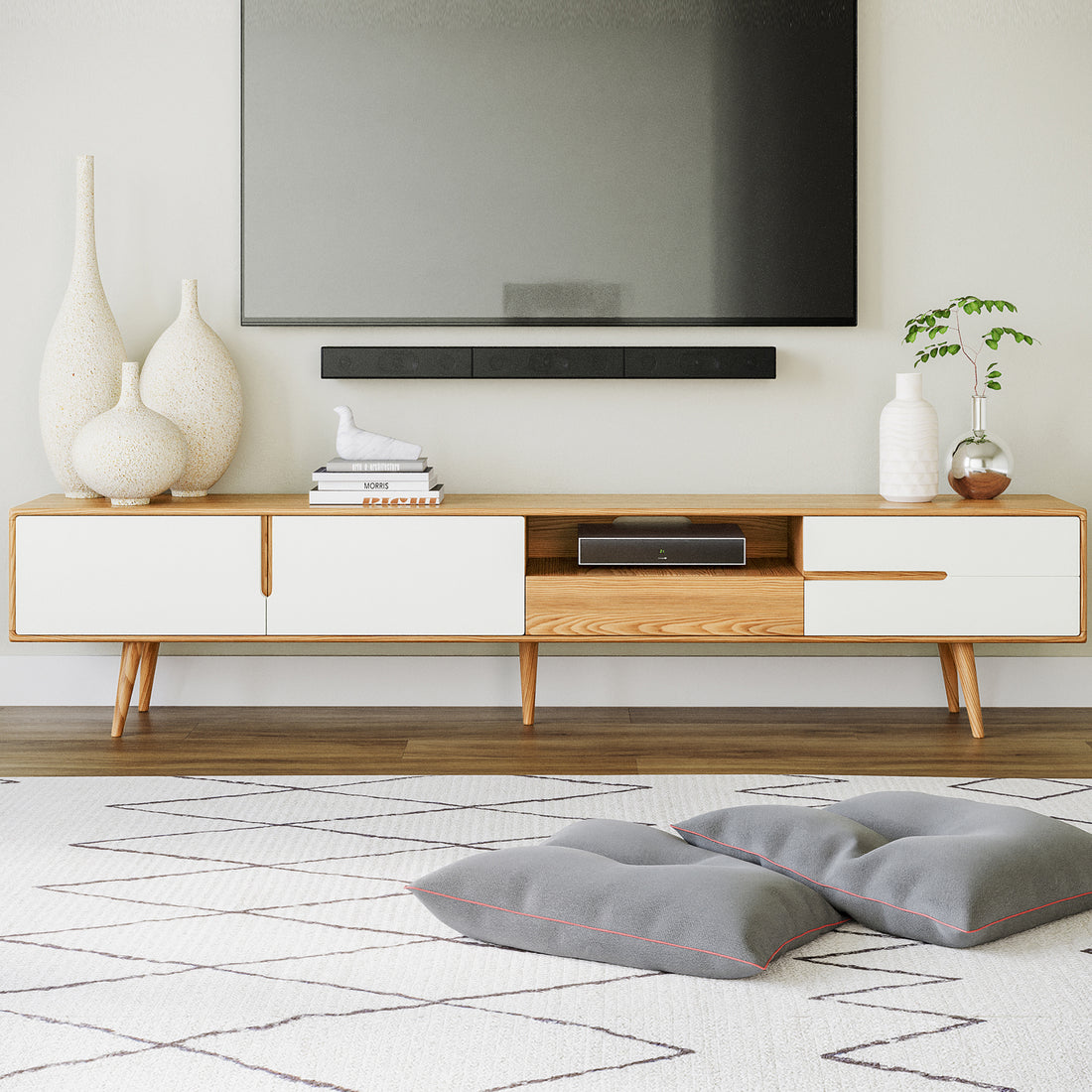 Estella 200cm American Oak Entertainment Unit in Natural with white-fronted drawers, topped with ceramic vases, books, and a bird figurine. Underneath, a cubby holds a cable box. Scandinavian style.