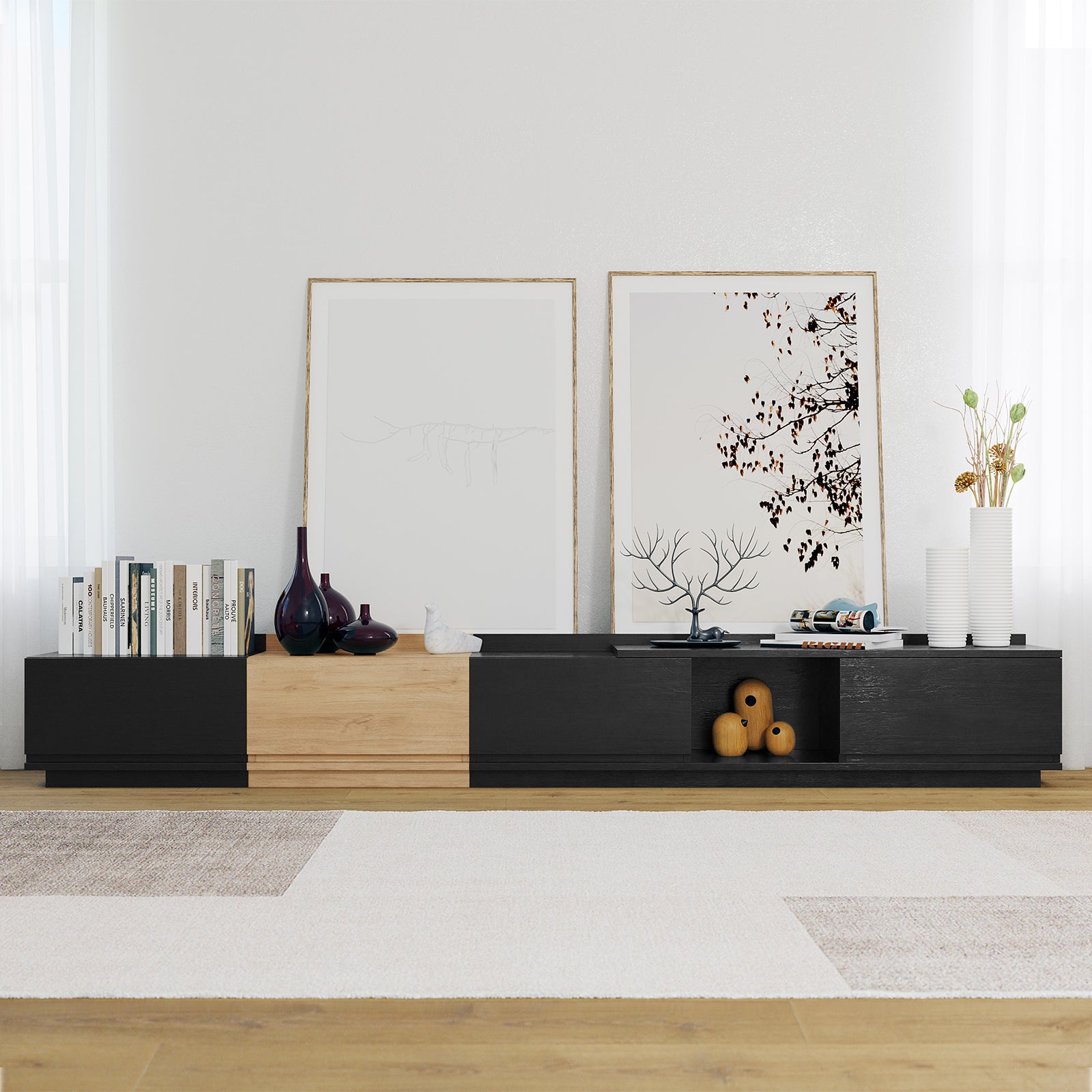 Freda 280cm Modular Entertainment TV Unit in Black & Natural features alternating panels, topped with books, vases, and decor, set against a white wall with sheer curtains, on a wooden floor.