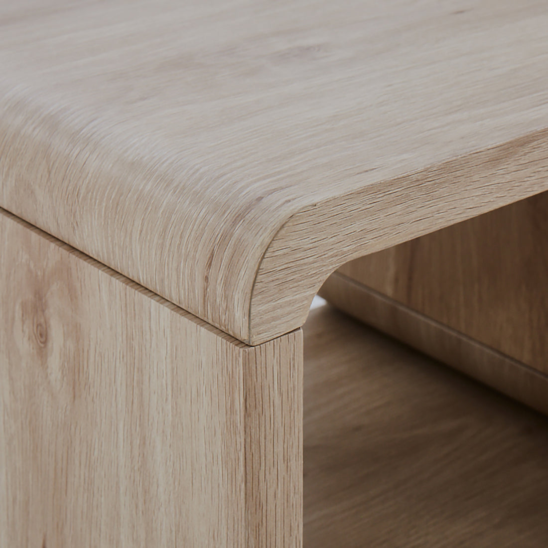 Close-up of the Galya Extendable Storage TV Unit in Oak, showcasing its rounded upper corner and open shelf beneath, highlighting its modern design and practical storage features.