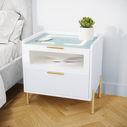 Gwen Smart Bedside Table with Wireless Charger in White, featuring two drawers, brass accents, and a built-in charging pad with LED strip. Topped with a potted succulent and smartphone.