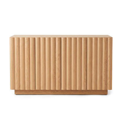 Oak sideboard featuring vertical fluted door panels and a low plinth base against a plain white studio background.