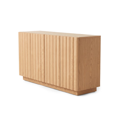 Oak sideboard with vertical fluted panels and a solid plinth base angled against a plain white studio background.