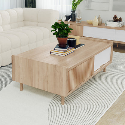 Hayden 130cm Coffee Table with Storage in Natural, featuring a rectangular wooden design on a light rug, adorned with a peace lily, books, and candles, in a minimalist living room setting.