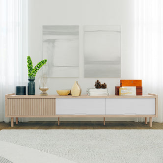 Hayden 200cm Fluted TV Entertainment Unit in Natural displayed with decorative items: a dark metal cylinder, blue vase, glass vessel, wooden bowls, magazines, and a keepsake box, creating a minimalist, chic living-room setup.