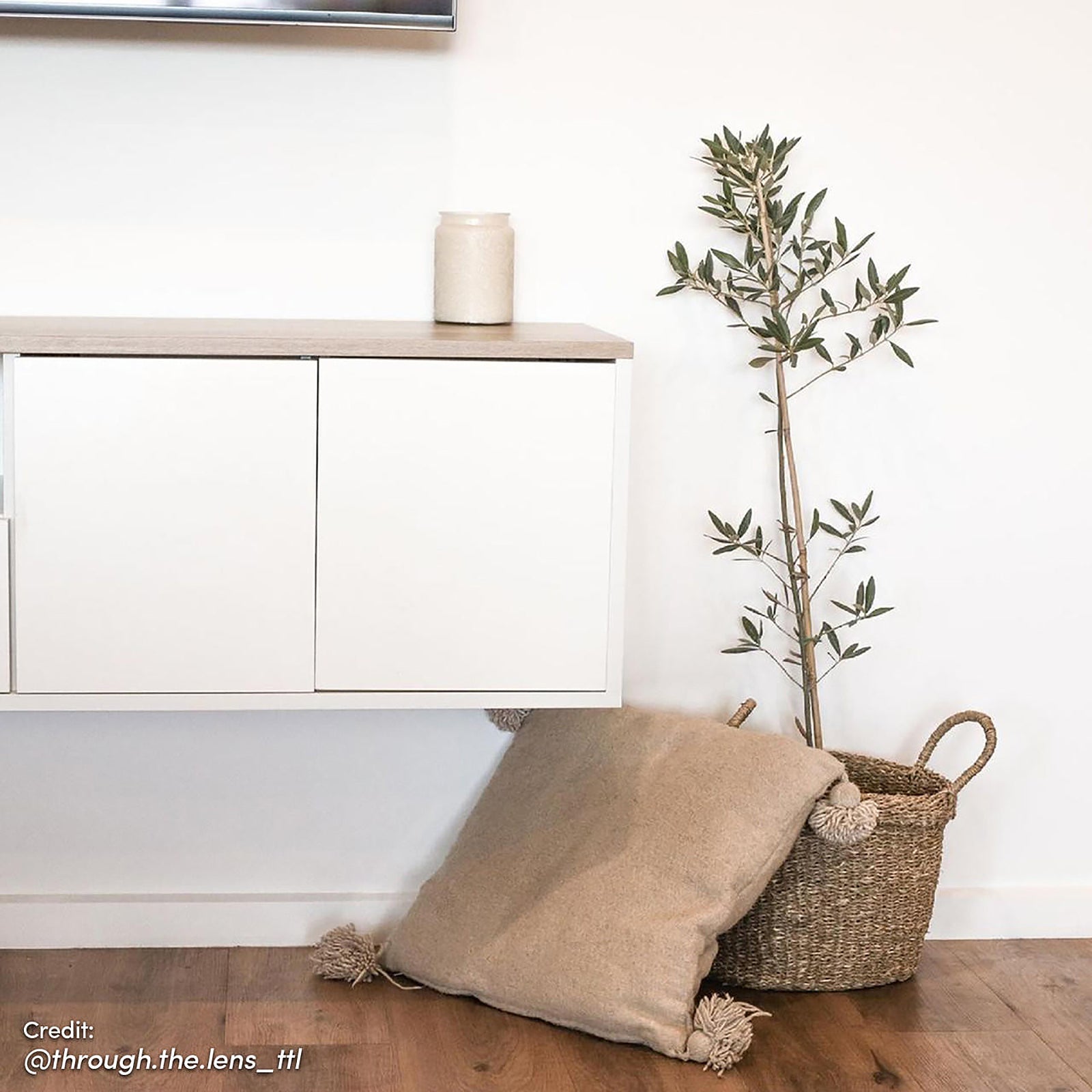 Leslie 180cm Floating Entertainment Unit in White & Natural, featuring a wall-mounted white cabinet with a wood-tone top, complements the modern decor with a chic, handleless design against a clean white backdrop.