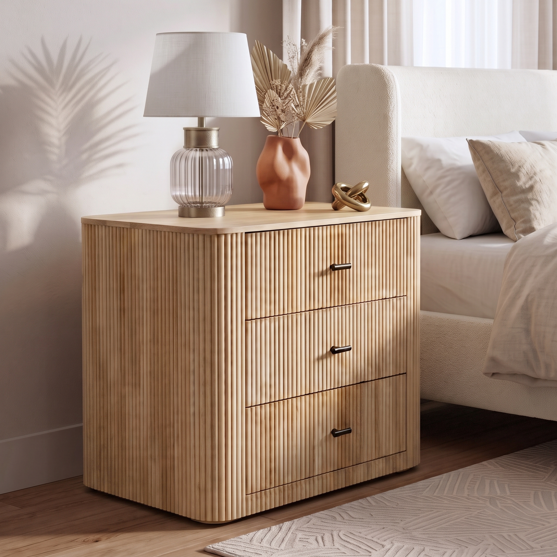Wooden three-drawer nightstand styled beside a bed in a cozy bedroom
