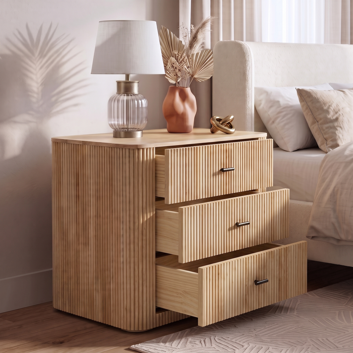Wooden dresser styled beside a bed with lamp and decor in a bedroom