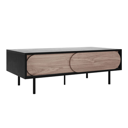 Novia 120cm Coffee Table with Sliding Doors in Black features a sleek black frame with slim legs and two sliding wooden panels, revealing storage cubbies for organized, modern living room functionality.
