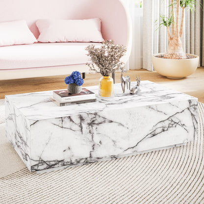 Parviz 88cm Rectangular Coffee Table in Marble, featuring a sleek marble finish with books, a charcoal pot of blue flowers, an amber vase, and metallic deer figurines, complements the pale-pink sofa.