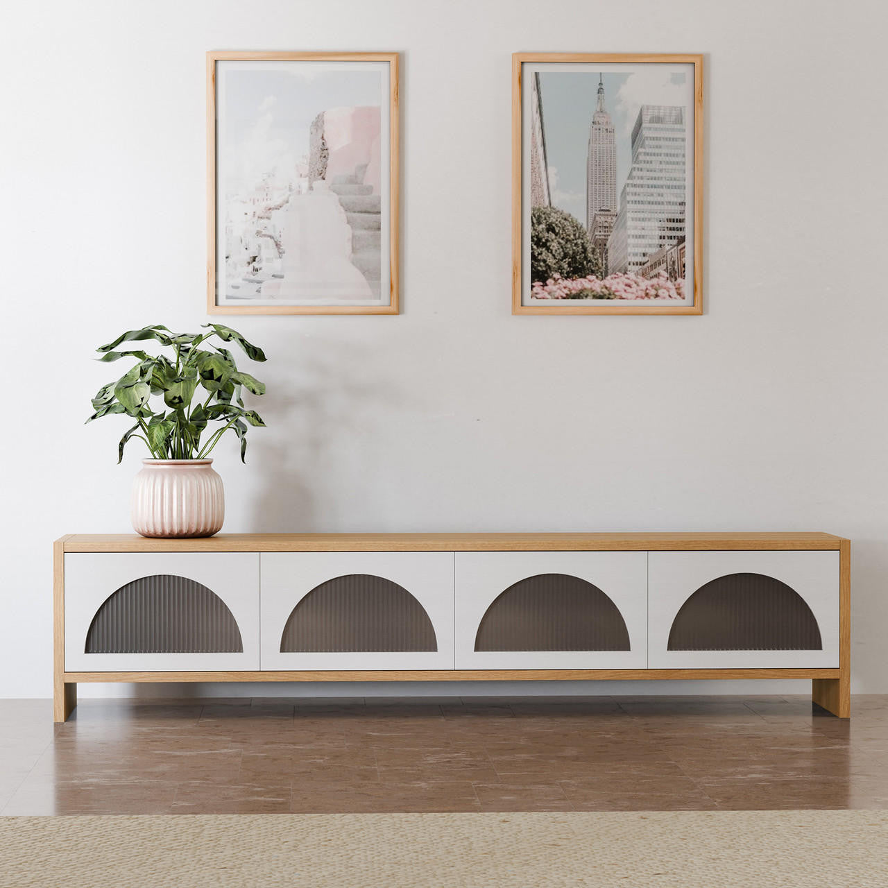 Philippe 200cm Arch Door TV Entertainment Unit in Natural features a low wooden console with four fluted-glass half-circle doors, topped with a planter, beneath framed prints on a white wall.