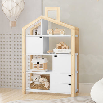 Quinta Shelf Unit with Storage White & Natural, featuring a house-shaped design with toys and blocks displayed on its shelves, a woven basket with plush toys, and a decorative hot-air-balloon mobile above.