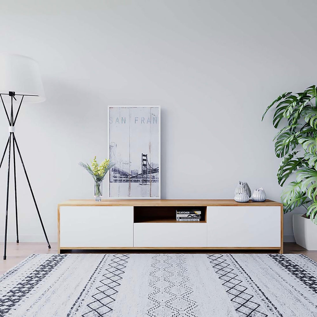 Rocco Entertainment Unit with Shelves in White, featuring a low wood-and-white design, topped with a vase, print, and vases. Books in the open cubby, styled with a floor lamp and houseplant.
