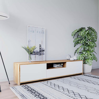 Rocco Entertainment Unit with Shelves in White: A sleek, low media console with open shelving, books, decorative vessels, and a leaning print, accompanied by a glass vase and potted plant.