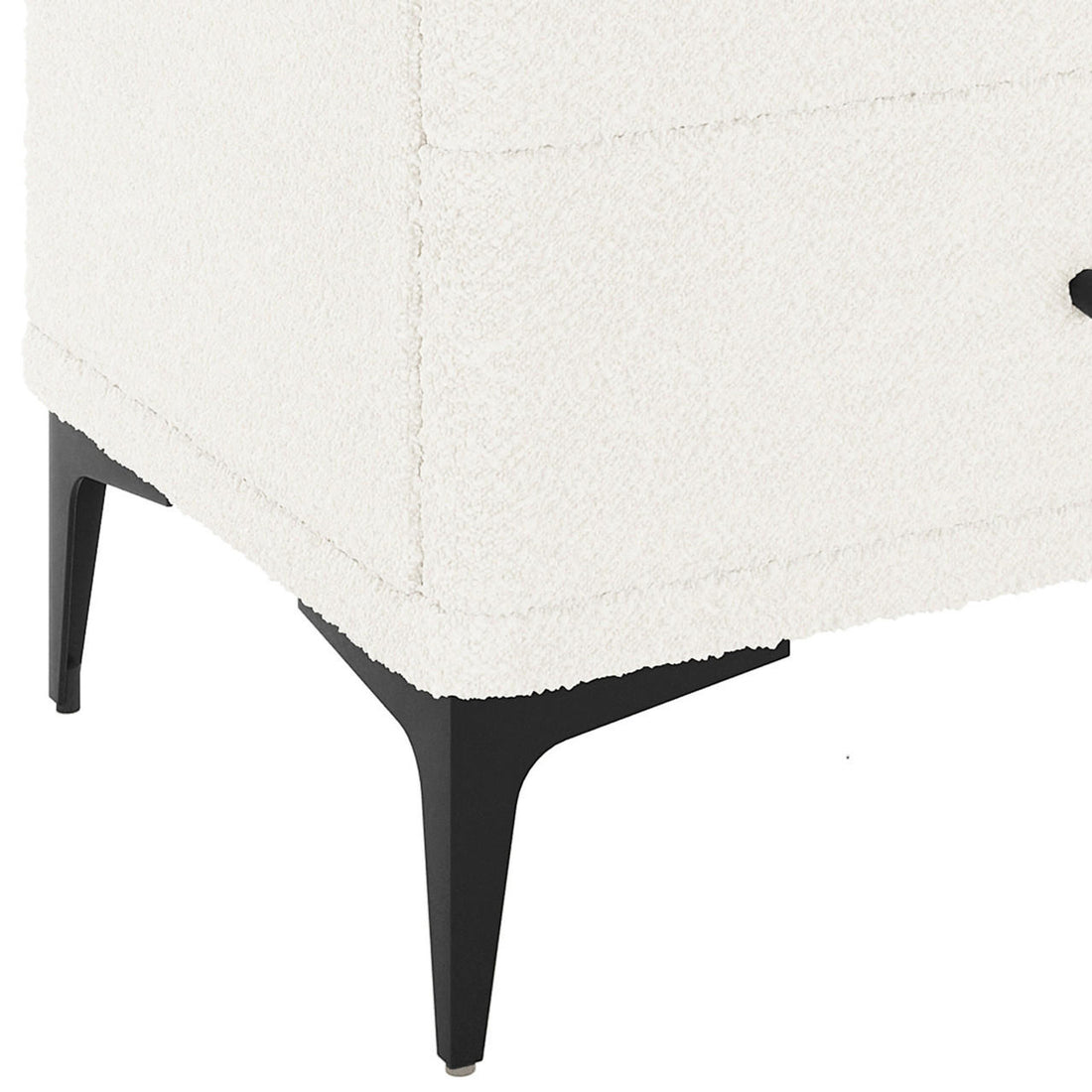 Shona Upholstered Boucle Bedside Table in Cream White, showcasing a corner with white textured fabric, supported by slim, tapered black metal legs, highlighting its modern elegance and functional design.