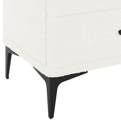 Shona Upholstered Boucle Bedside Table in Cream White, showcasing a corner with white textured fabric, supported by slim, tapered black metal legs, highlighting its modern elegance and functional design.
