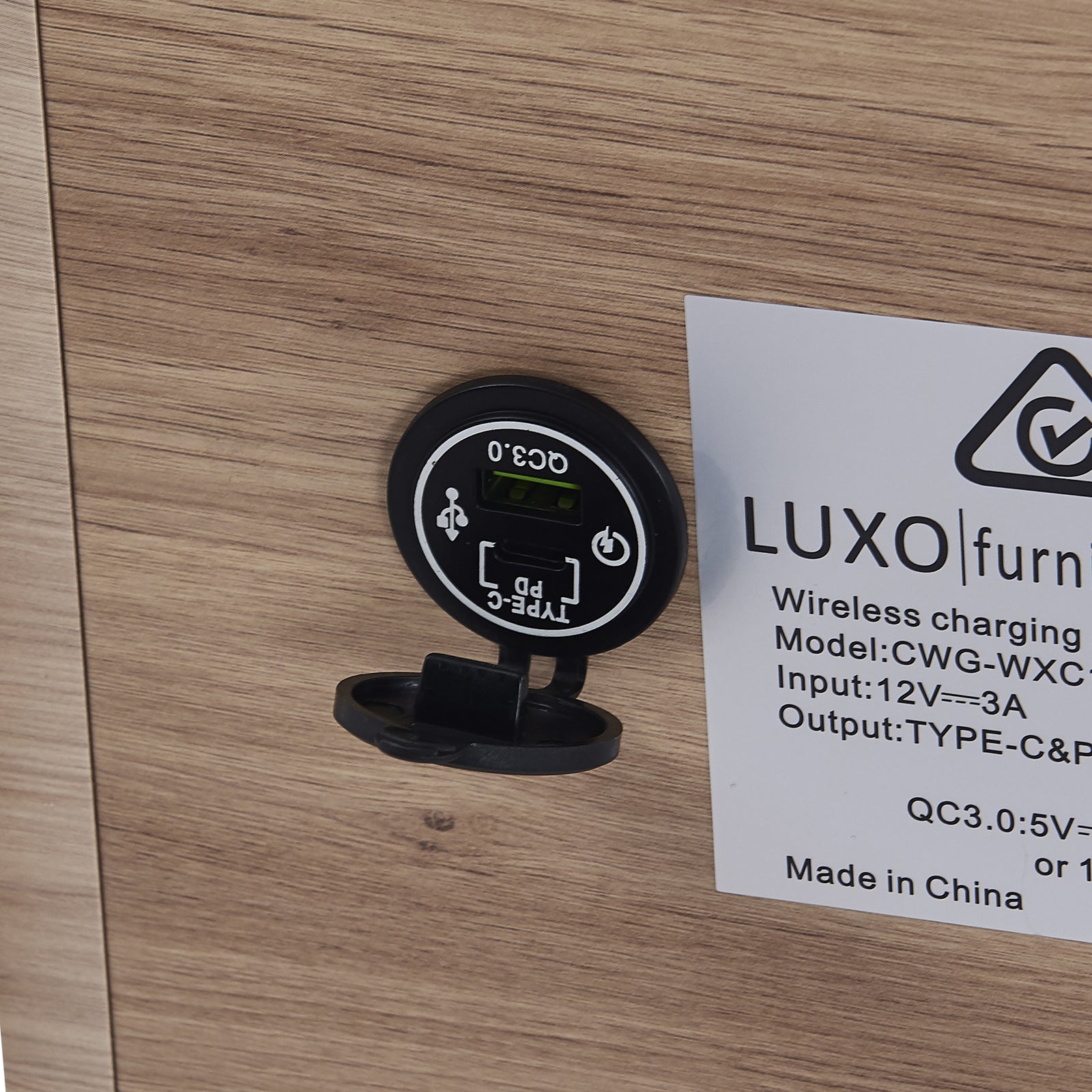 Close-up of the Zayn Smart Bedside Table with Wireless Charger, highlighting the sleek design with a Qi wireless charger on the tabletop and a black triangle with a check mark symbol.