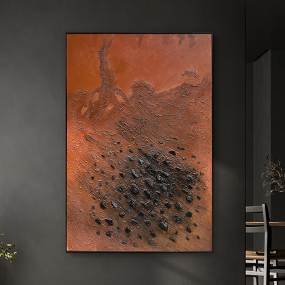 Ember 120x180cm Framed Textured Canvas 3D Wall Art features a burnt-orange and terracotta abstract design with charcoal-black specks, set in a slim black frame against a dark gray wall.
