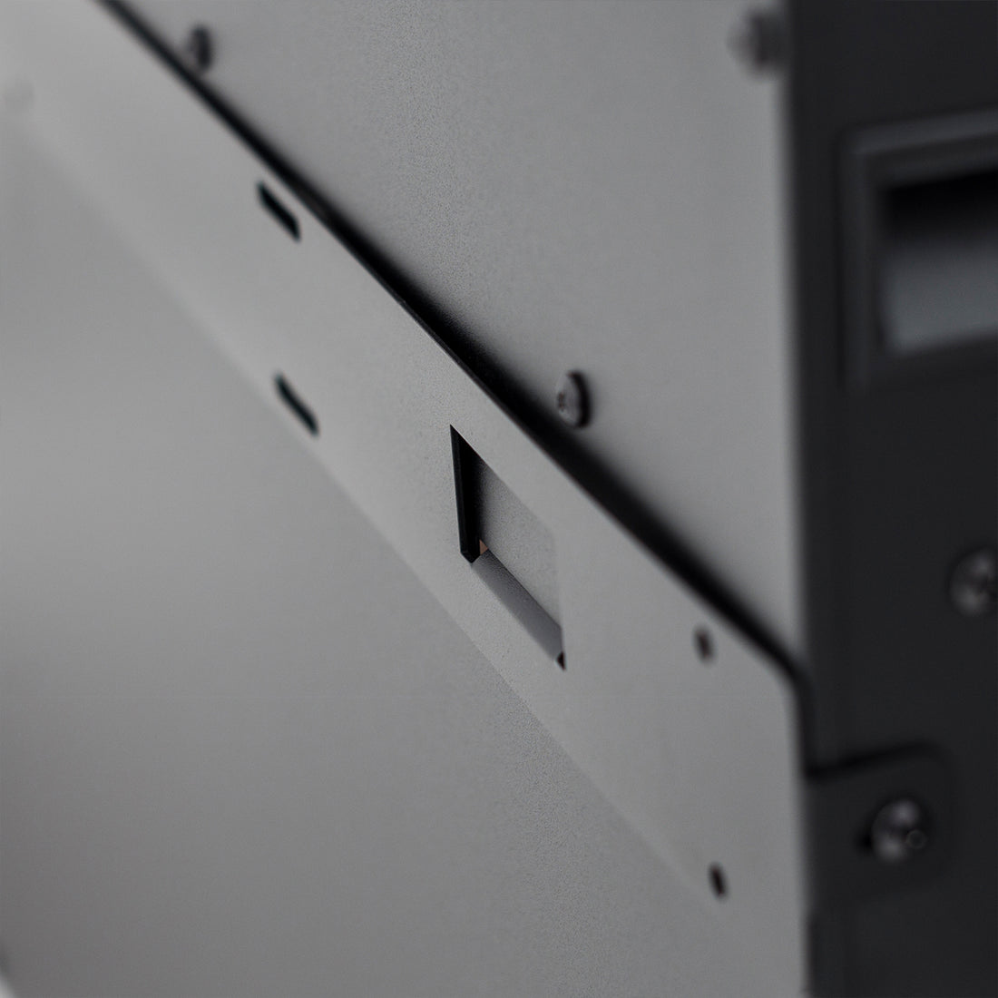 Close-up of Dakota 60 Wall Mounted 1500W Electric Fireplace Heater, showcasing a textured gray steel panel with a central latch and black screws, emphasizing its sleek, space-saving design.