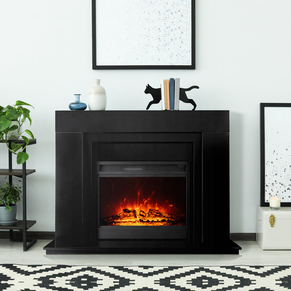 Oprah 1950W Free Standing Electric Mantel Fireplace in Black, featuring a sleek design with a minimalist mantel, decorative vases, books, and a bold geometric rug enhancing the cozy ambiance.
