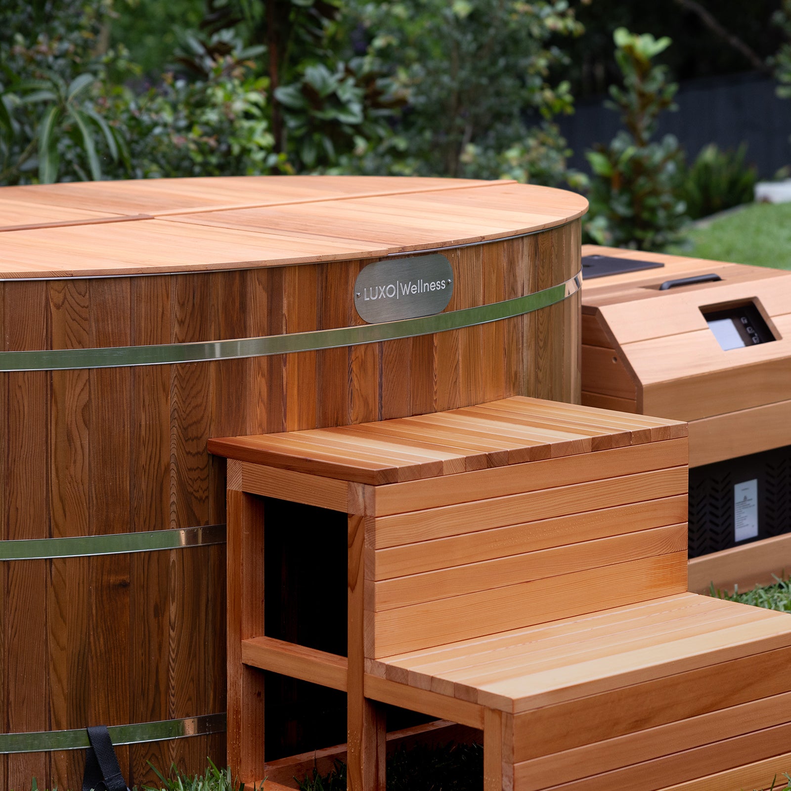 Denman 2 Person Outdoor Ice Bath with 1.5HP Chiller in Natural, featuring a wooden barrel-style design and matching entry bench, set outdoors with visible heater/control housing.