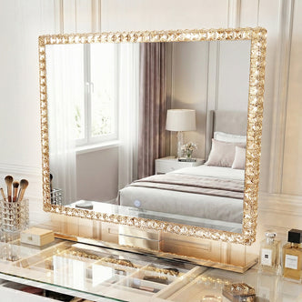 Rectangular crystal-bordered vanity mirror with LED lights on a styled vanity in a bedroom