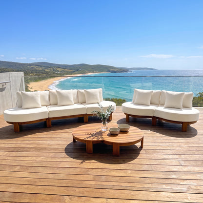 Outdoor sofa set with coffee table on a terrace overlooking the ocean and beach.