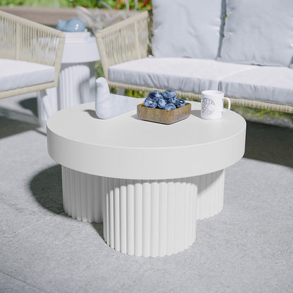 Basalt 70cm Indoor & Outdoor Concrete Coffee Table in White with fluted legs, topped with a bird sculpture, wooden bowl of blueberries, and dotted ceramic mug, set in a cozy patio setting.