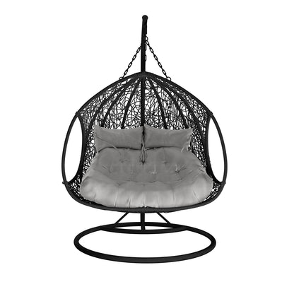 Basin 2-Seater Hanging Egg Chair with Cushion in Black features a black metal frame, woven shell, and plush seat with back pillows, suspended by a chain on a round base.