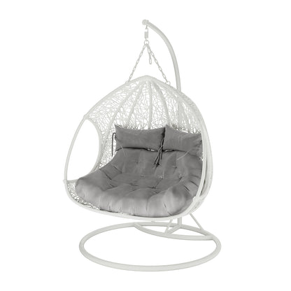 Basin 2-Seater Hanging Egg Chair with Cushion in White, featuring a woven open-lace pattern and sturdy metal base, includes a thick tufted cushion and two lumbar pillows for comfort.