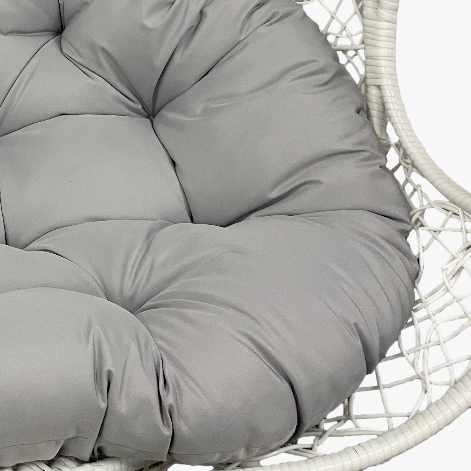 Close-up of the Basin 2-Seater Hanging Egg Chair with Cushion in White, showcasing the tufted gray cushion nestled in a white woven rattan-style chair frame, emphasizing its modern and comfortable design.