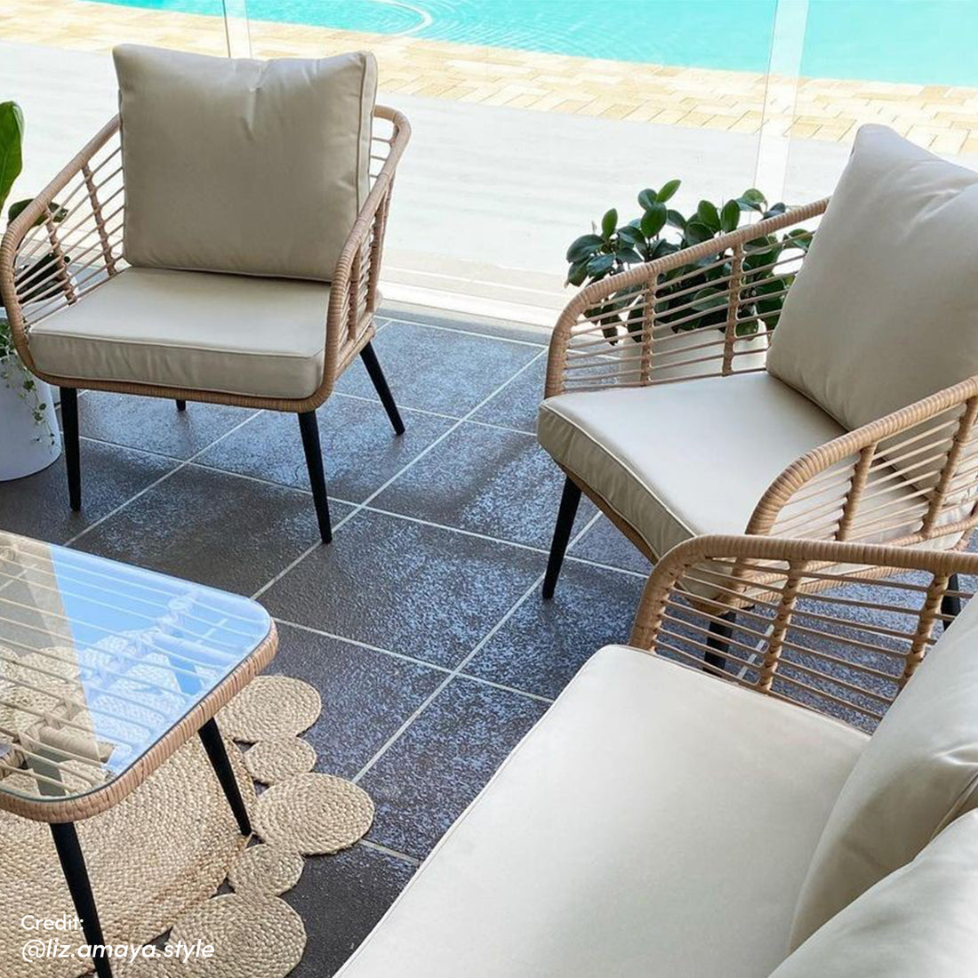 Bequia 4 Seater Rope Wicker Outdoor Sofa Light Beige on a patio, featuring a rope-wicker design with plush cushions, adjacent to a matching coffee table with glass top, set for outdoor relaxation.