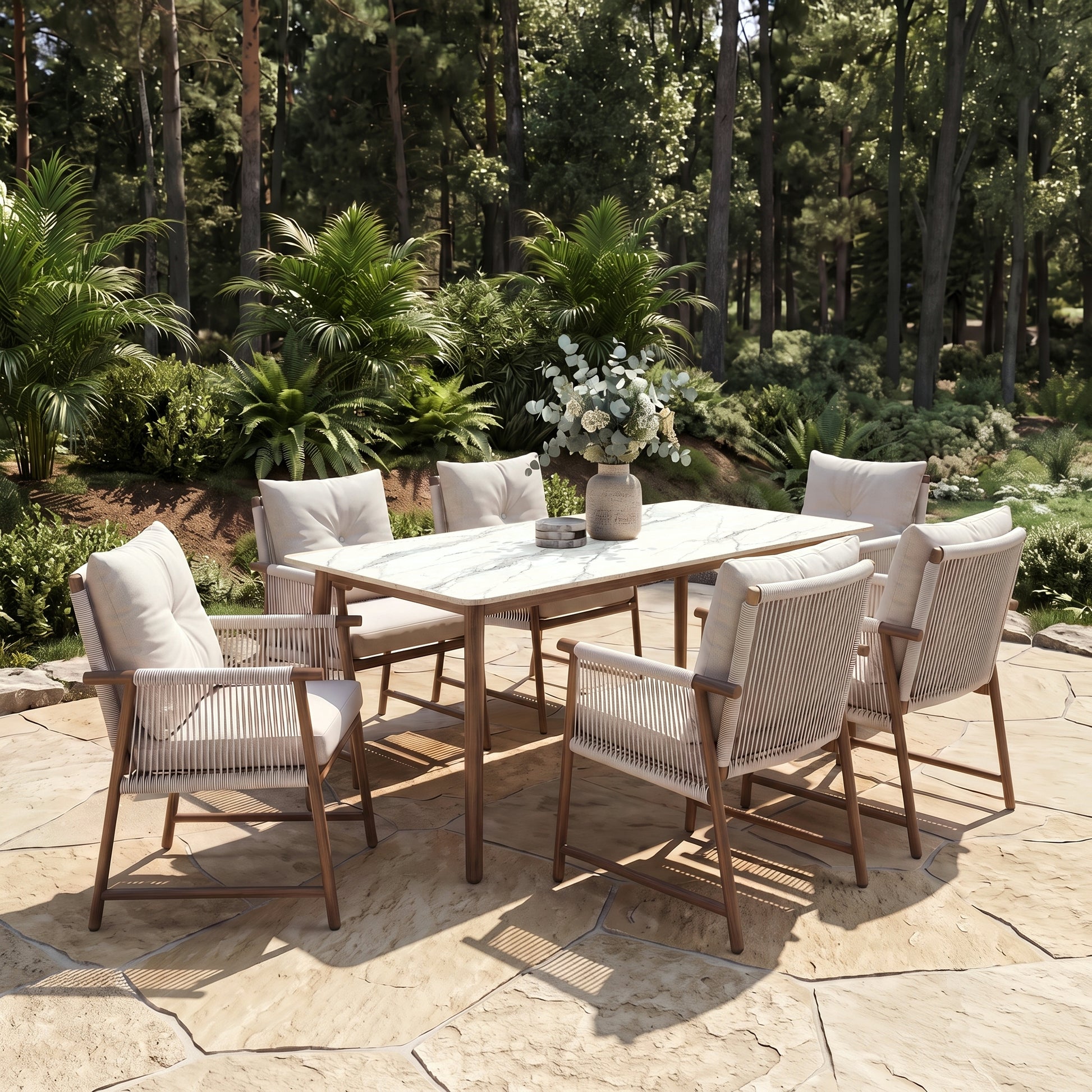 Outdoor dining set with table and chairs on a stone patio surrounded by greenery