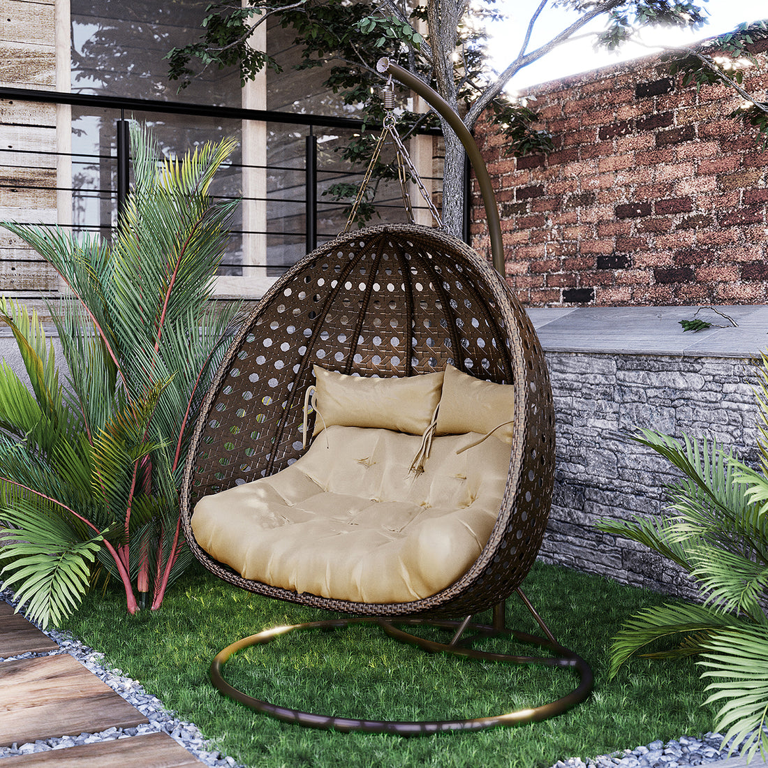Buena 2 Person Wicker Outdoor Hanging Egg Chair in Brown, featuring a cozy double pod with tufted beige cushions, suspended from a sturdy metal stand amidst tropical plants and a modern outdoor setting.