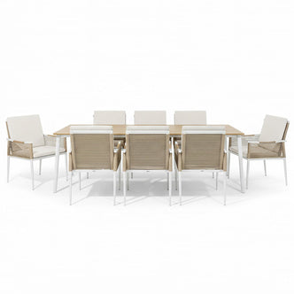 Casara 9 Piece Outdoor Dining Set in White and Beige features a light-wood table with white metal legs, six side chairs, and two armchairs with beige rope-woven backs and cushioned seats.
