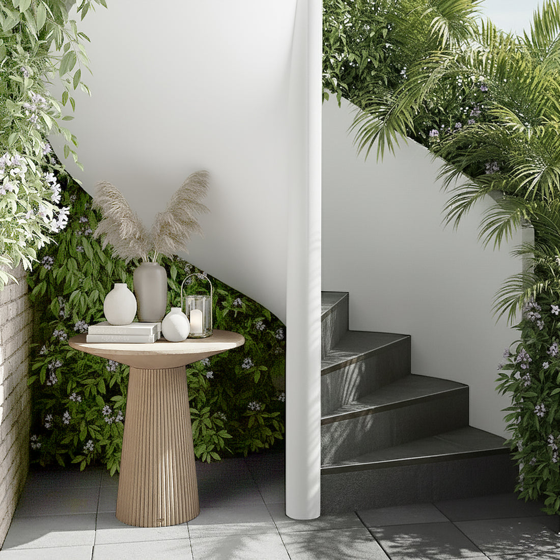 Darien 80cm Round Concrete Hallway Table in Ivory with fluted base, atop a grey tiled floor, styled with pampas grass in a tall vase, ceramic vases, books, and a candle lantern.