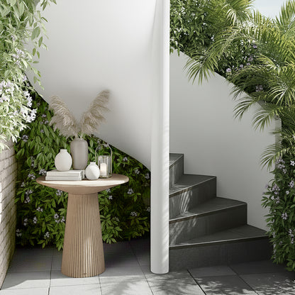 Darien 80cm Round Concrete Hallway Table in Ivory with fluted base, atop a grey tiled floor, styled with pampas grass in a tall vase, ceramic vases, books, and a candle lantern.