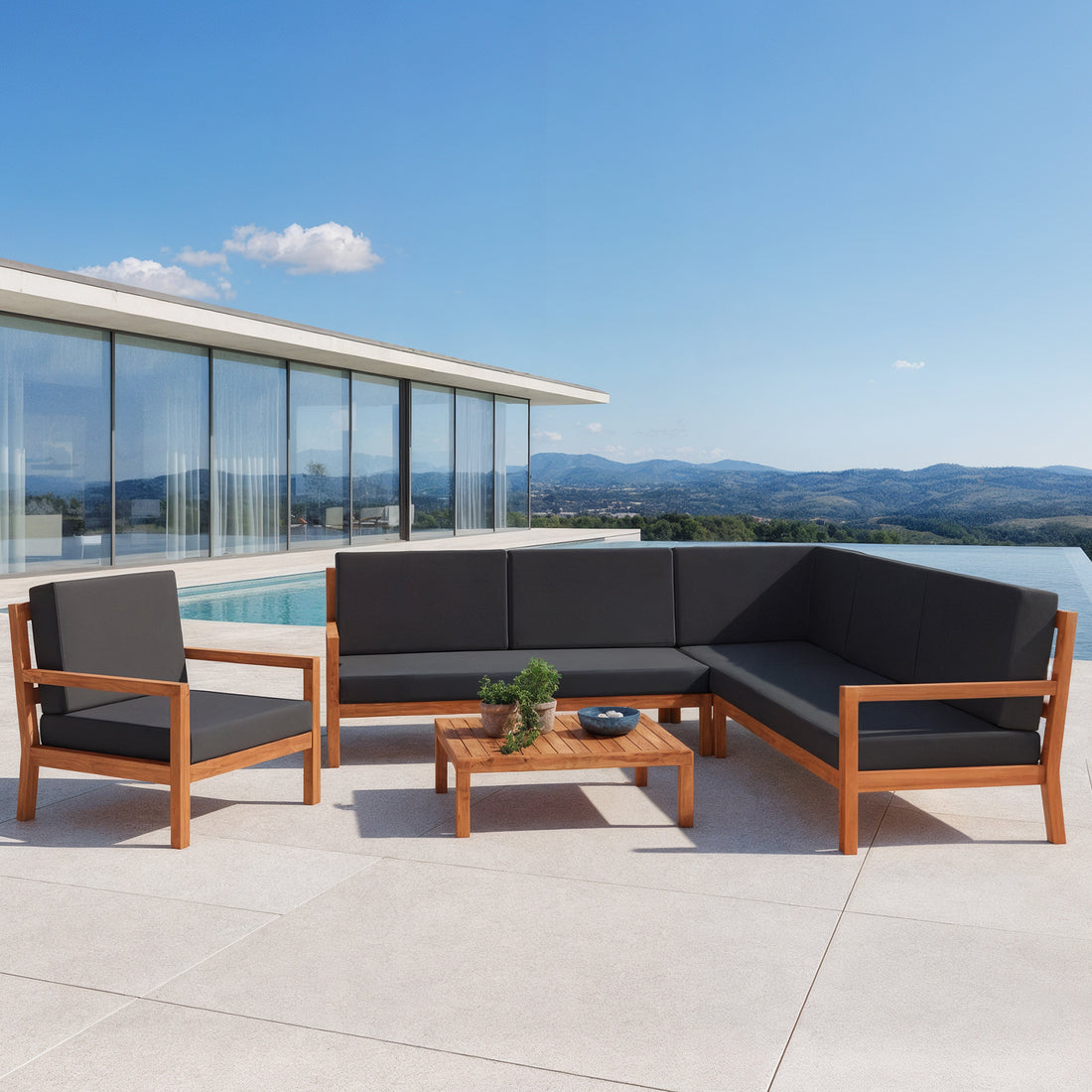 Haiti 7 Seater Hardwood Outdoor Sofa Set in Black beside a pool, featuring an L-shaped wooden-frame sectional with dark grey cushions, a matching lounge chair, and a low wooden coffee table with plants.