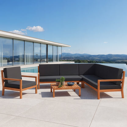 Haiti 7 Seater Hardwood Outdoor Sofa Set in Black beside a pool, featuring an L-shaped wooden-frame sectional with dark grey cushions, a matching lounge chair, and a low wooden coffee table with plants.