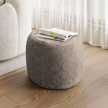 Close-up of the Hollie Indoor/Outdoor Round Concrete Side Table with a magazine on top, showcasing its sturdy, natural concrete design and versatile use in modern farmhouse decor.