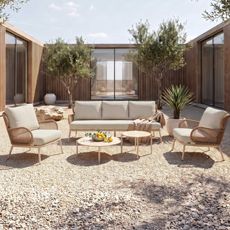 Outdoor patio seating set arranged in a courtyard with cushions and coffee tables